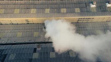 Los humos tóxicos se propagan desde el techo de una planta industrial. Las plantas industriales emiten grandes cantidades de humo de las fábricas durante la producción. que crea la contaminación del aire para el mundo. foto