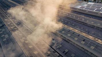 Toxic fumes spread from the roof of an industrial plant. Industrial plants emit large amounts of smoke from the factories during production. which creates air pollution for the world. photo