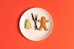 gingerbread cookies are laid out in the shape of a clock around the hour hands. Happy new year concept photo