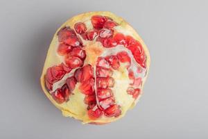 red pomegranate seeds on gray background photo