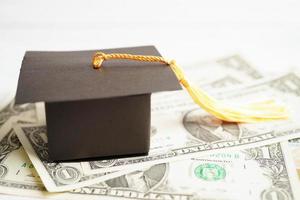 sombrero de la brecha de graduación en el dinero de los billetes en dólares estadounidenses, concepto de enseñanza de aprendizaje de la tarifa de estudio de educación. foto