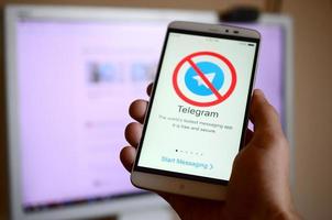KHARKOV, UKRAINE - MAY 8, 2022 A mobile phone with the Telegram app screen with a prohibiting sign. Roskomnadzor blocked the Telegram service in Russia. Access to telegram messenger is closed photo