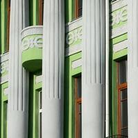 antiguo edificio restaurado de varias plantas con columnas antiguas, pintado de verde foto