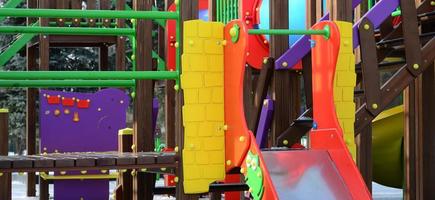 Fragment of a playground made of plastic and wood, painted in different colors photo