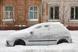 kharkov, ucrania - 4 de enero de 2022 un automóvil estacionado bajo una gruesa capa de nieve. consecuencias de una fuerte e inesperada nevada en ucrania foto