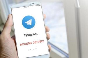 kharkov, ucrania - 27 de abril de 2022 un teléfono móvil con la pantalla de la aplicación de telegramas con un cartel de prohibición. roskomnadzor bloqueó el servicio de telegramas en rusia. el acceso a telegram messenger esta cerrado foto