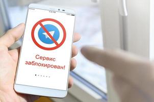 KHARKOV, UKRAINE - APRIL 27, 2022 A mobile phone with the Telegram app screen with a prohibiting sign and russian inscription Access is denied. Roskomnadzor blocked the Telegram service in Russia photo