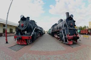 Photo of old black steam locomotives of the Soviet Union. Strong distortion from the fisheye lens