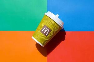 KHARKOV, UKRAINE - MAY 12, 2022 McDonald's paper disposable coffee cup on bright colors mix background photo