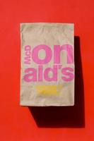 KHARKOV. UKRAINE - MAY 17, 2022 Close up of a McDonald's Take Away Food Brown Paper Bag on red background photo