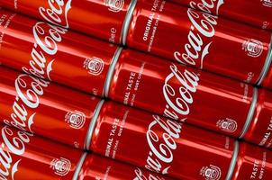 KHARKOV. UKRAINE - MAY 2, 2022 Coca-Cola logo printed on aluminium tin cans close up in shopping mall photo