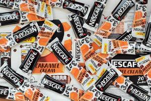 KHARKOV. UKRAINE - MAY 2, 2022 Many Nescafe caramel cream coffee sticks. Nescafe is a brand of coffee made by Nestle, swiss multinational conglomerate corporation photo