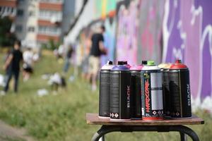 KHARKOV. UKRAINE - MAY 17, 2022 Used Montana black and hardcore aerosol spray cans against graffiti paintings. MTN or Montana-cans is manufacturer of high pressure spray paint goods photo