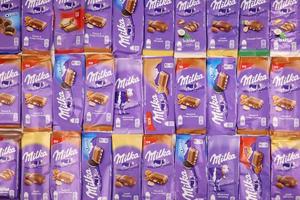 KHARKOV, UKRAINE - MAY 5, 2022 Many wrappings of purple Milka chocolate. Milka is a Swiss brand of chocolate confection manufactured by company Mondelez International photo