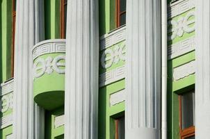 Restored old multi-storey building with antique columns, painted in green photo