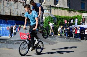 KHARKIV, UKRAINE - 27 MAY, 2022 Freestyle BMX riders in a skatepark during the annual festival of street cultures photo
