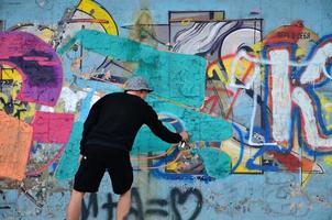 KHARKOV, UKRAINE - MAY 27, 2022 Festival of street arts. Young guys draw graffiti on an old concrete walls in the center of the city. The process of painting on walls with aerosol spray cans photo