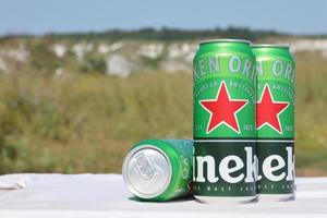 KHARKOV, UKRAINE - MAY 12, 2022 Green tin cans of Heineken lager beer produced by the Dutch brewing company Heineken N.V. photo