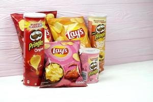 kharkov, ucrania - 12 de mayo de 2022 varios sabores de papas fritas lay's y pringles en diseño de paquetes clásicos. marcas mundialmente famosas de papas fritas foto