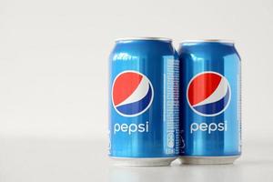 KHARKOV, UKRAINE - MAY 5, 2022 Cold Pepsi drink cans om white background. Pepsi is a carbonated soft drink produced by PepsiCo photo