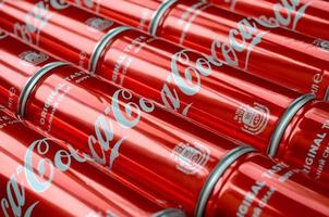 KHARKOV. UKRAINE - MAY 2, 2022 Coca-Cola logo printed on aluminium tin cans close up in shopping mall photo