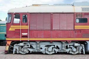Cabin of modern Russian electric train. Side view of the head of railway train with a lot of wheels and windows in the form of portholes photo