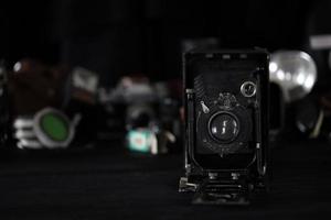 KHARKOV, UKRAINE - MAY 12, 2022 Fotokor-1 Film photo camera and another old retro photo equipment on black wooden table in photographer darkroom. Photographic gear from soviet union