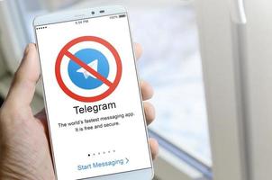 KHARKOV, UKRAINE - APRIL 27, 2022 A mobile phone with the Telegram app screen with a prohibiting sign. Roskomnadzor blocked the Telegram service in Russia. Access to telegram messenger is closed photo