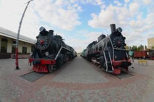 Photo of old black steam locomotives of the Soviet Union. Strong distortion from the fisheye lens
