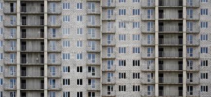 Textured pattern of a russian whitestone residential house building wall with many windows and balcony under construction photo