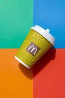 KHARKOV, UKRAINE - MAY 12, 2022 McDonald's paper disposable coffee cup on bright colors mix background photo