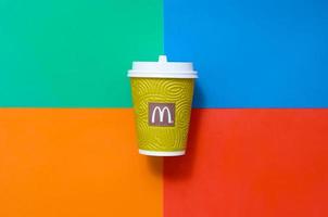 KHARKOV, UKRAINE - MAY 12, 2022 McDonald's paper disposable coffee cup on bright colors mix background photo