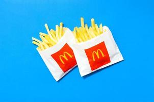 KHARKOV. UKRAINE - MAY 17, 2022 McDonald's French fries in small paperbag on bright blue background photo