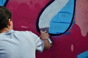 KHARKOV, UKRAINE - MAY 27, 2017 Festival of street arts. Young guys draw graffiti on portable wooden walls in the center of the city. The process of painting on walls with aerosol spray cans photo