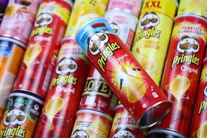 KHARKOV, UKRAINE - MAY 12, 2022 Many Pringles cylinder chips boxes with varios colors and flavours. American brand of stackable potato-based crisps photo