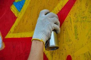 KHARKOV, UKRAINE - MAY 27, 2022 Festival of street arts. Young guys draw graffiti on portable wooden walls in the center of the city. The process of painting on walls with aerosol spray cans photo