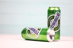 KHARKOV, UKRAINE - MAY 5, 2022 Aluminium cans of green Tuborg beer on wooden background. Tuborg is Danish brewing company founded in 1873 photo