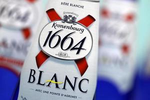 KHARKOV. UKRAINE - MAY 17, 2022 Blanc logo on beer bottles on white table. 1664 Blanc is the wheat beer from French brewery Kronenbourg exported worldwide photo