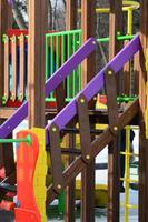 Fragment of a playground made of plastic and wood, painted in different colors photo