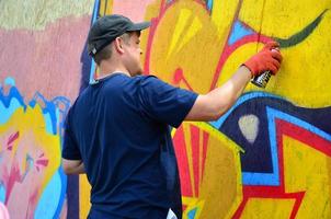 KHARKOV, UKRAINE - MAY 27, 2022 Festival of street arts. Young guys draw graffiti on portable wooden walls in the center of the city. The process of painting on walls with aerosol spray cans photo