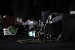 KHARKOV. UKRAINE - MAY 2, 2022 Fotokor-1 Film photo camera and another old retro photo equipment on black wooden table in photographer darkroom. Photographic gear from soviet union