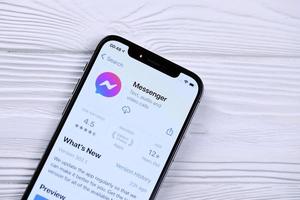KHARKOV. UKRAINE - MAY 2, 2022 Facebook messenger icon and application from App store on iPhone 12 pro display screen on white table photo