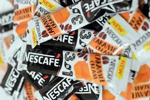 KHARKOV. UKRAINE - MAY 2, 2022 Many Nescafe caramel cream coffee sticks. Nescafe is a brand of coffee made by Nestle, swiss multinational conglomerate corporation photo