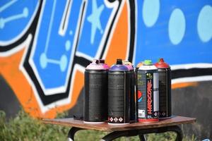 KHARKOV. UKRAINE - MAY 2, 2022 Used Montana black and hardcore aerosol spray cans against graffiti paintings. MTN or Montana-cans is manufacturer of high pressure spray paint goods photo