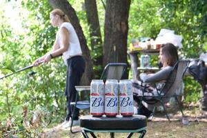 KHARKOV. UKRAINE - MAY 2, 2022 Many Cans of Budweiser Lager Alcohol Beer lies on fishing background. Budweiser is Brand from Anheuser-Busch Inbev most popular in America photo