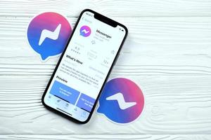kharkov, ucrania - 12 de mayo de 2022 icono de facebook messenger y aplicación de la tienda de aplicaciones en la pantalla de visualización del iphone 12 pro en la mesa blanca foto