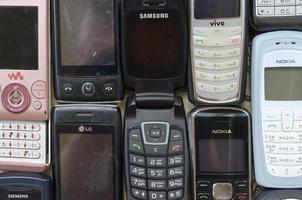 KHARKOV, UKRAINE - MAY 12, 2022 Some old used outdated mobile phones. Recycling electronics in the market cheap photo