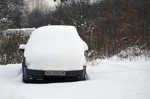 kharkov, ucrania - 4 de enero de 2022 un automóvil estacionado bajo una gruesa capa de nieve. consecuencias de una fuerte e inesperada nevada en ucrania foto