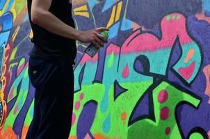 KHARKOV, UKRAINE - MAY 27, 2022 Festival of street arts. Young guys draw graffiti on portable wooden walls in the center of the city. The process of painting on walls with aerosol spray cans photo