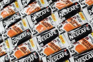 KHARKOV, UKRAINE - MAY 3, 2022 Many Nescafe caramel cream coffee sticks. Nescafe is a brand of coffee made by Nestle, swiss multinational conglomerate corporation photo